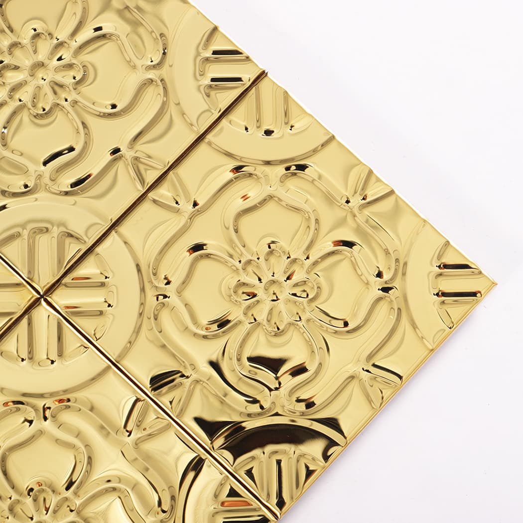 Close-up of a gold embossed floral medallion square tile showing reflective surface
