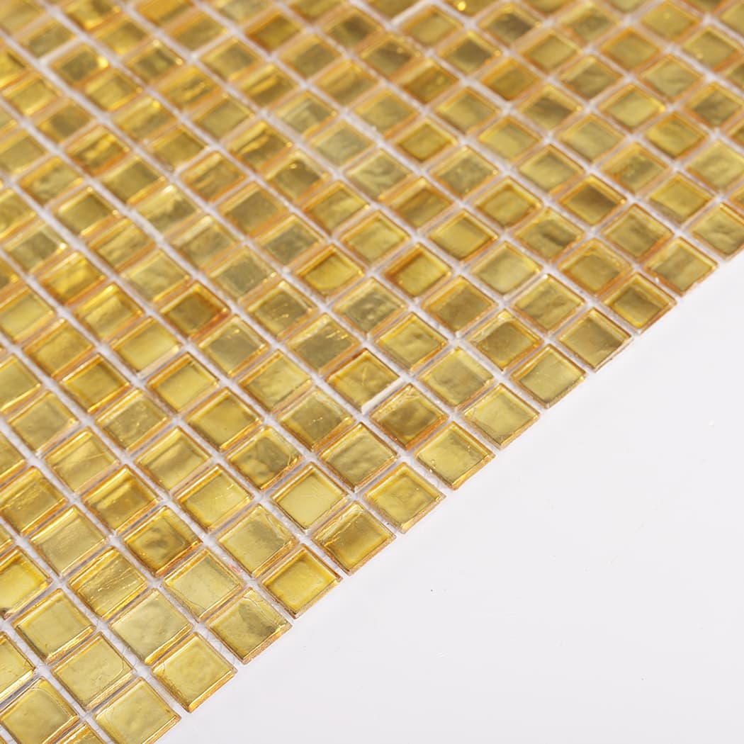 Angled view of gold foil glass square mosaic tile sheet highlighting glossy shine