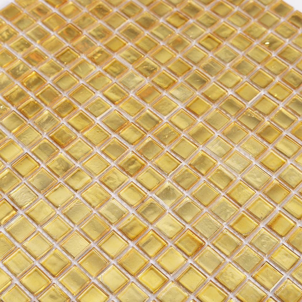 Close up of gold foil glass square mosaic tiles showing foil texture and shine