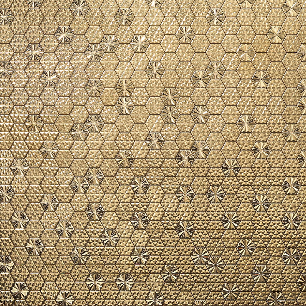 Close up of gold hexagon metal mosaic tile wall with repeating geometric pattern