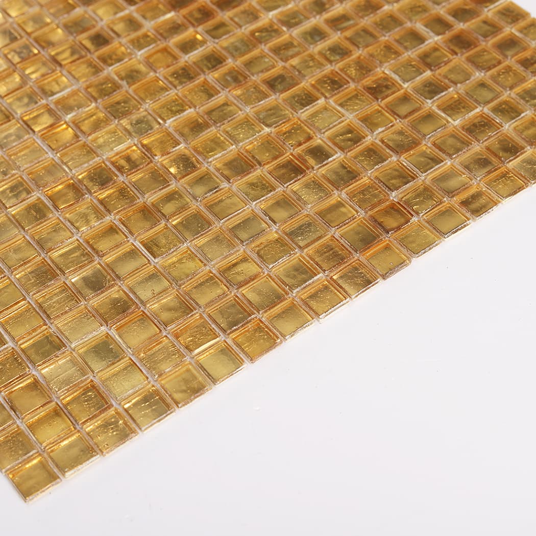 Angled view of gold leaf glass square mosaic tile sheet highlighting glossy shine