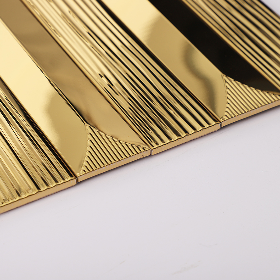 Angled edge view showing smooth and grooved surfaces of gold metallic mosaic tile.
