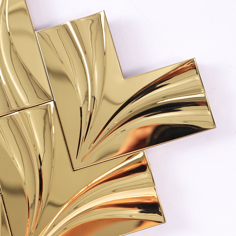 Close up corner of gold mirror herringbone stainless steel mosaic tile