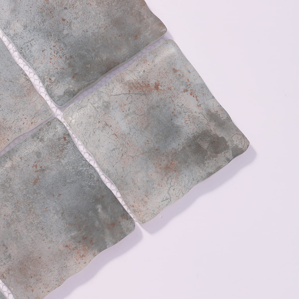 Close-up of gray beige wavy square glass mosaic tiles with cloudy texture