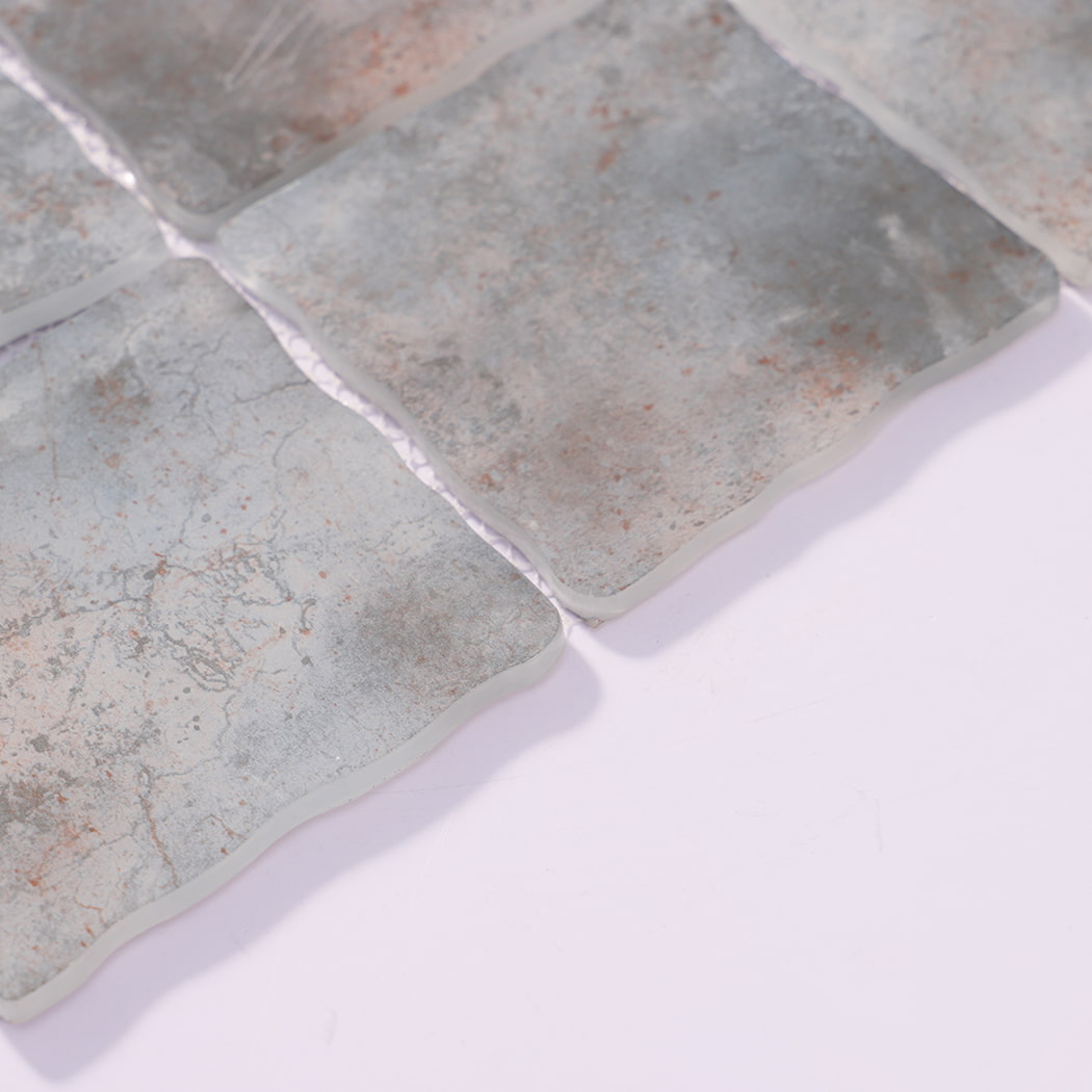 Edge detail of gray beige wavy square glass mosaic tiles on mesh