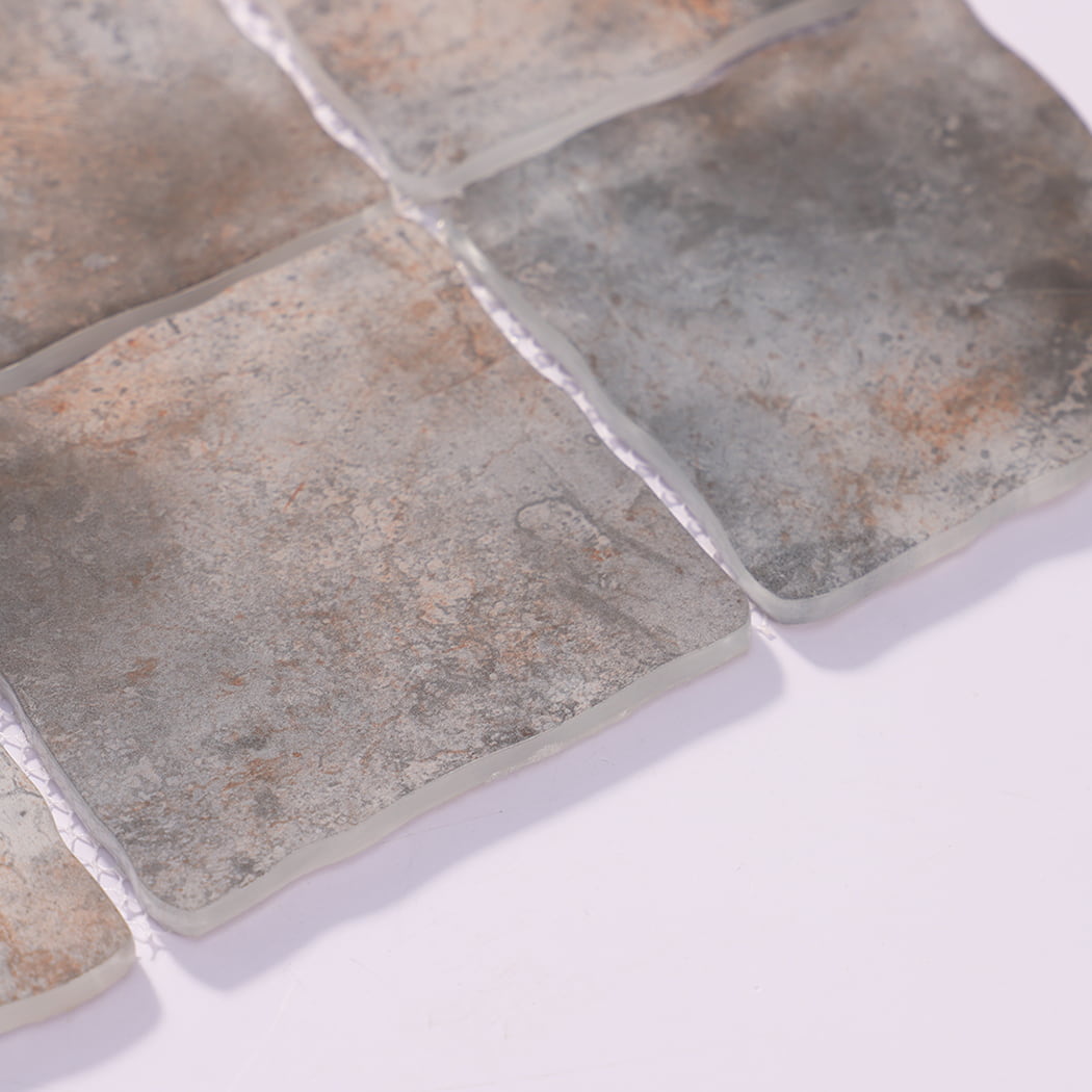 Edge detail of gray brown wavy square glass mosaic tiles on mesh