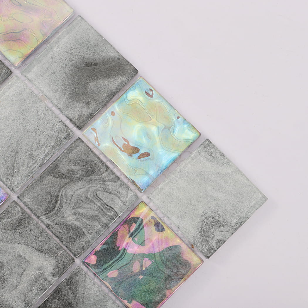 Close-up of gray square glass mosaic tiles with blue and pink iridescent accents