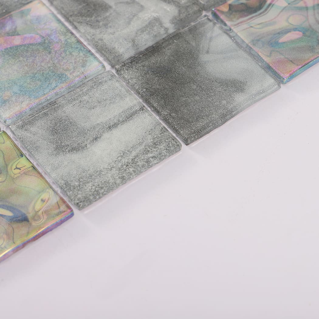Angled view of gray square glass mosaic tiles with colorful iridescent details