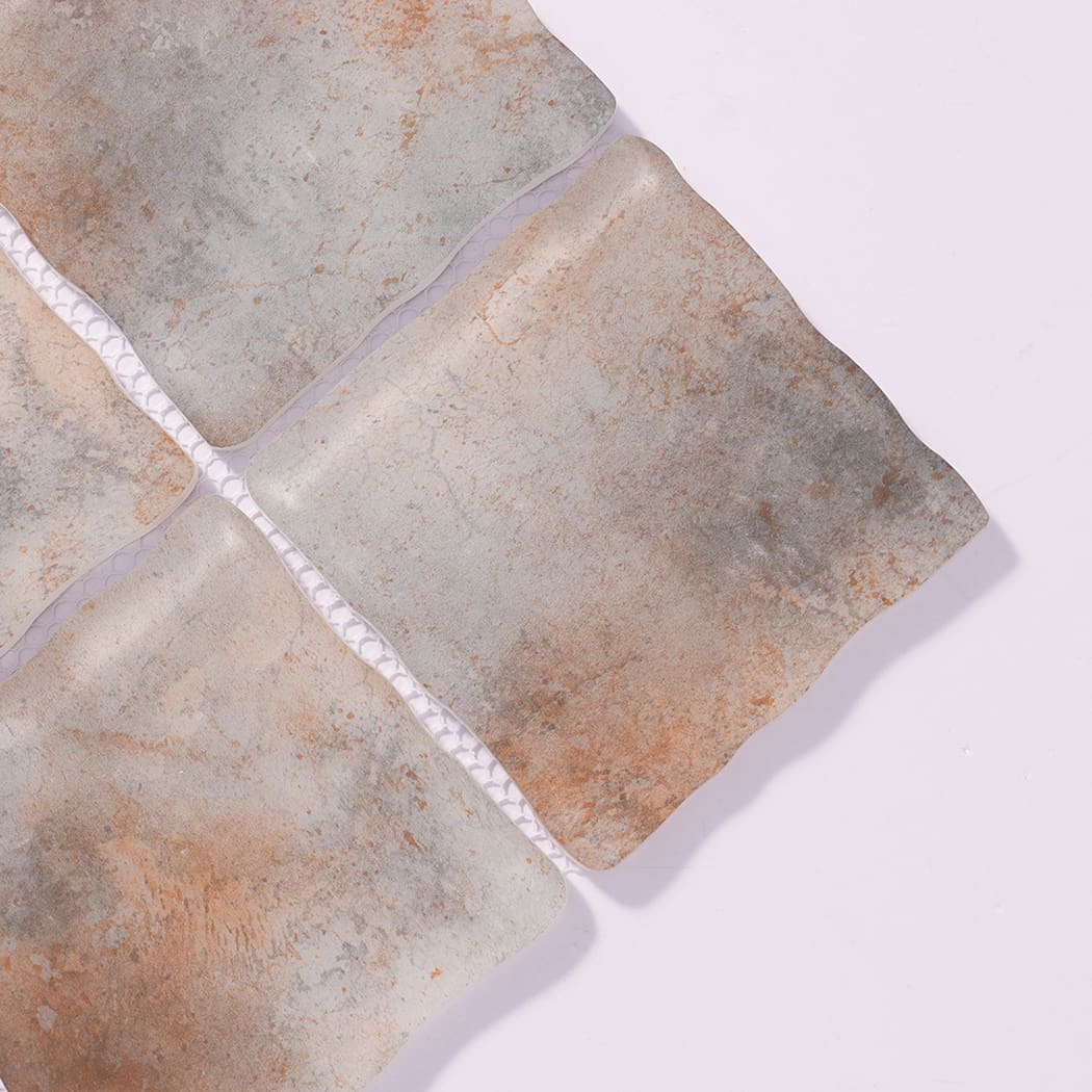 Close-up of gray rust orange wavy square glass mosaic tiles with mottled tones