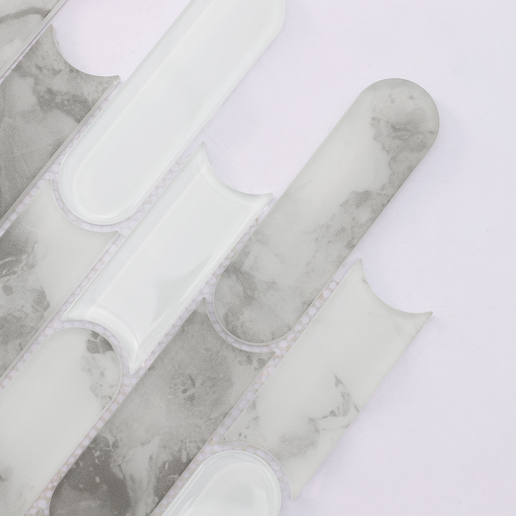 Close up of gray marble and white glass scalloped linear mosaic tile pattern