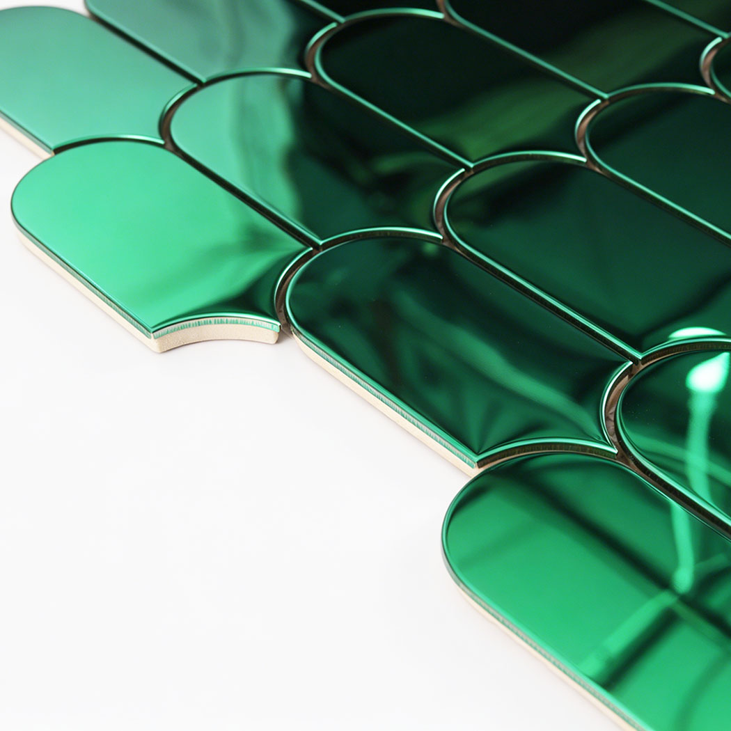 Side close up of green arch metal mosaic tile showing thickness and curved edges