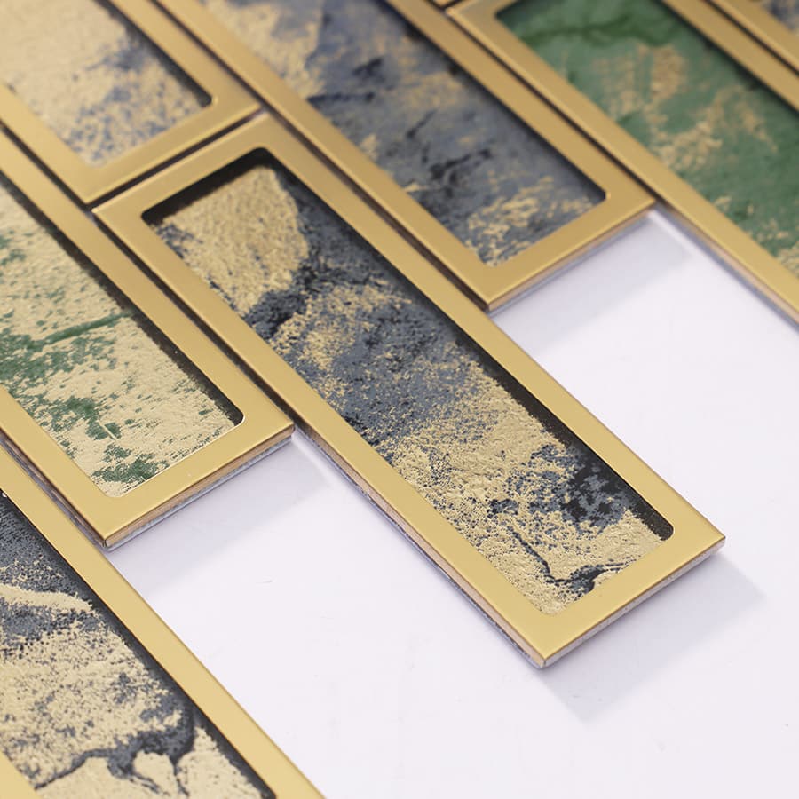 Close-up of green foil glass tile bordered by brushed gold stainless steel.