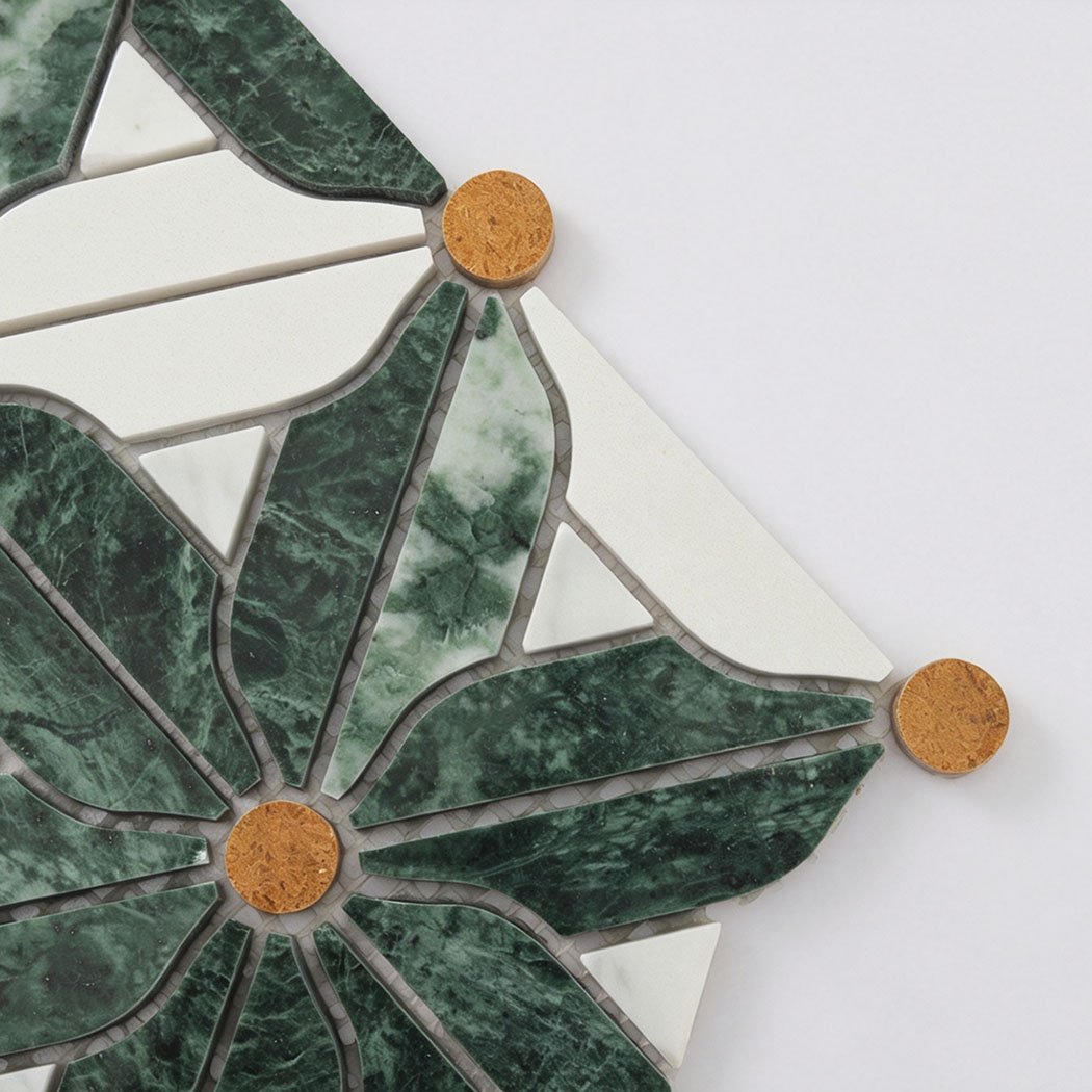 Close-up of green marble floral mosaic tile with white petals and golden accents