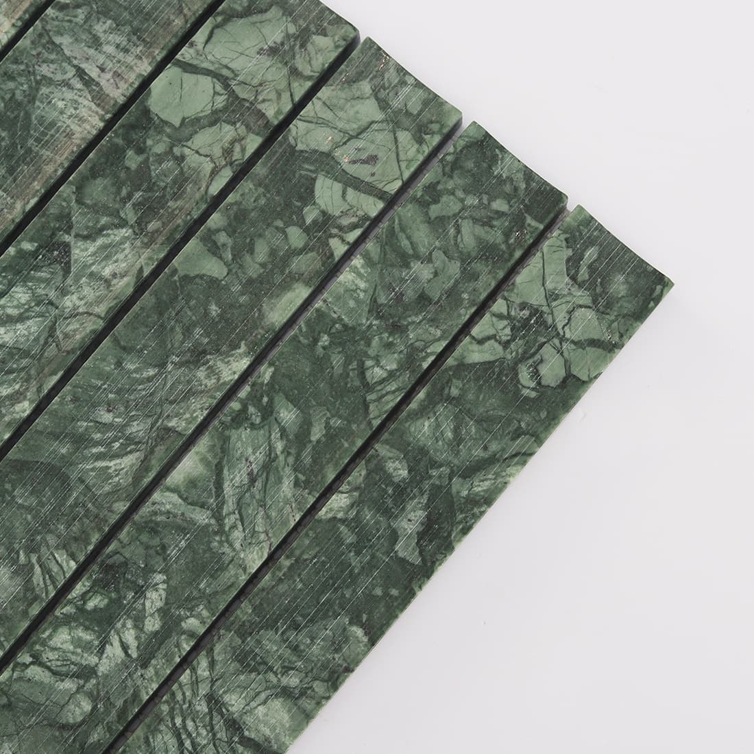 Close-up view of green marble mosaic tile strips with natural stone texture