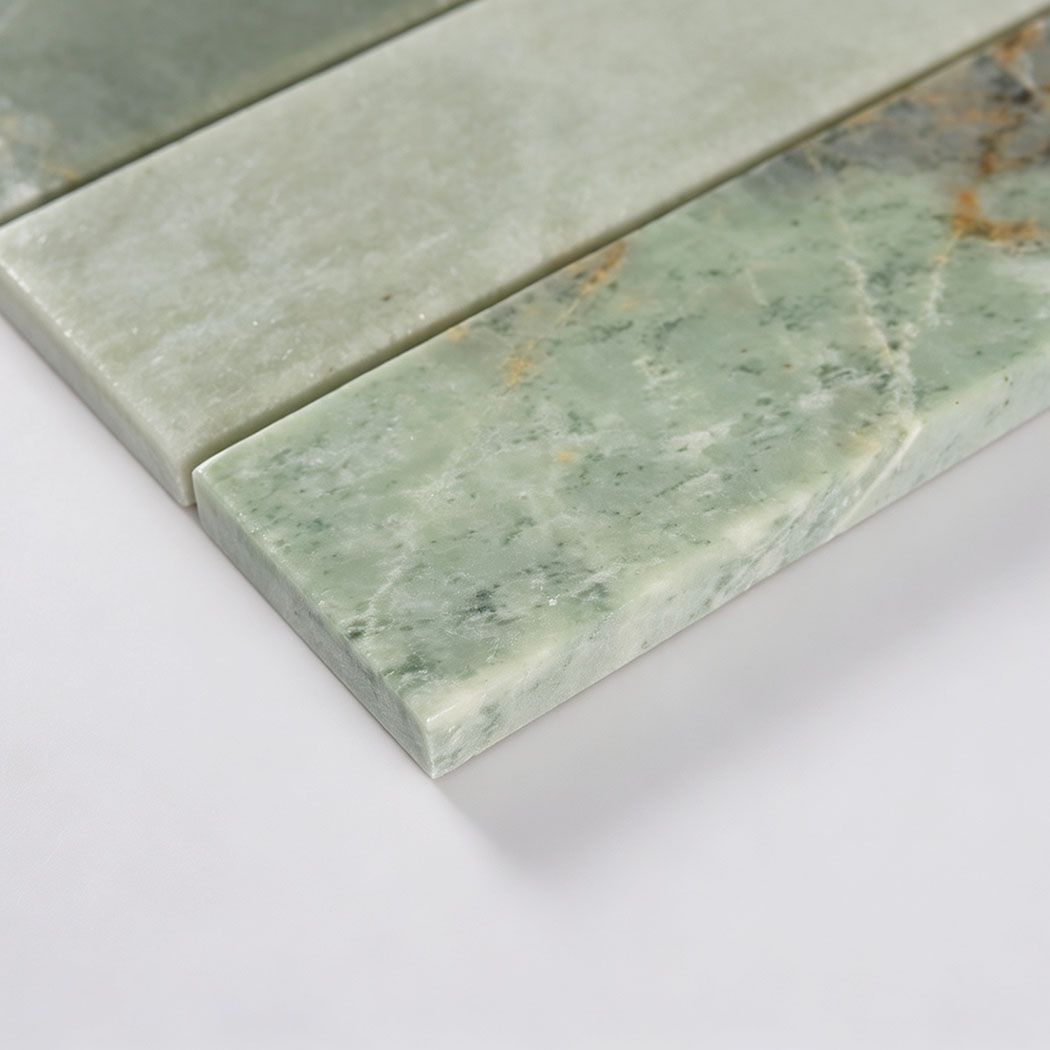 Edge close-up of green marble strip tile showing thickness and polished surface