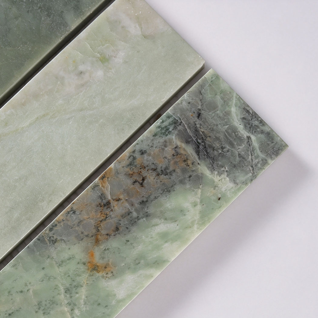 Close-up of green marble strip tile with gray veining and warm mineral accents