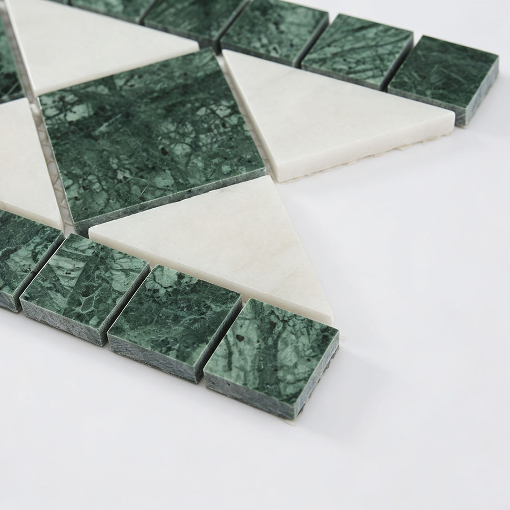 Close-up of green marble squares and white triangle mosaic tile pieces