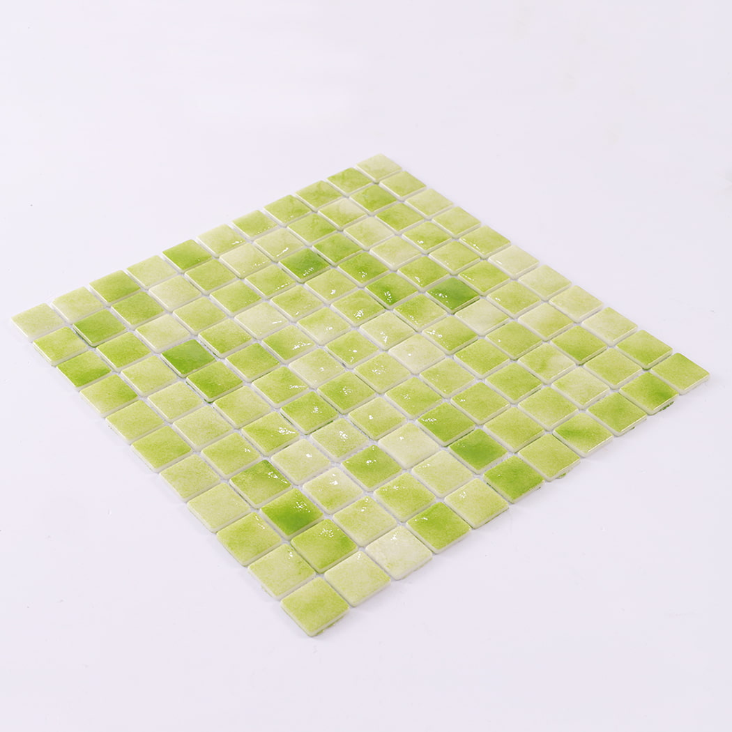 Angled view of green recycled glass square mosaic tile sheet