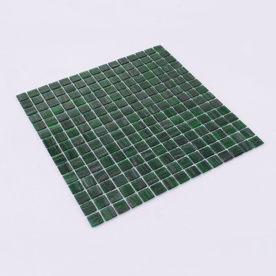 Angled view of green glass mosaic tile sheet on white background