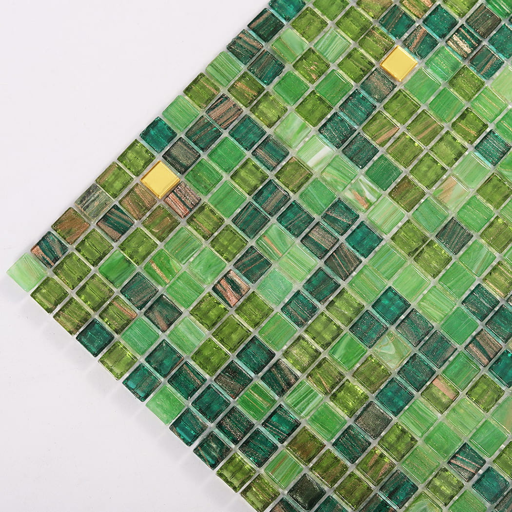 Close up corner of green glass mosaic tiles with glossy finish and gold accents
