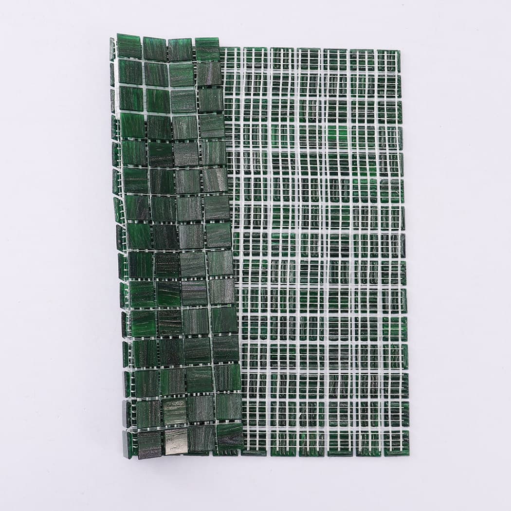 Back side of green glass mosaic tile showing mesh backing design
