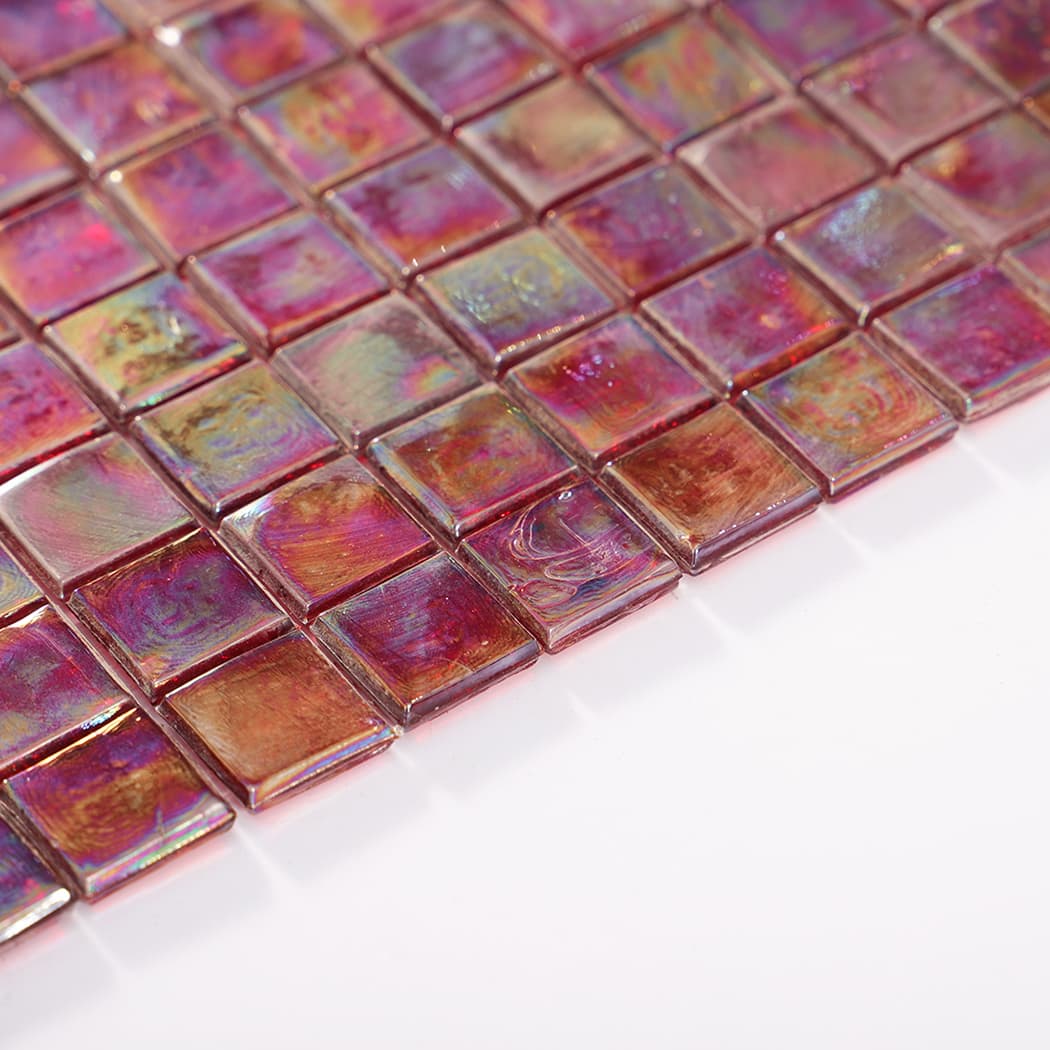 Low angle view of iridescent glass mosaic sheet highlighting tile thickness and shine