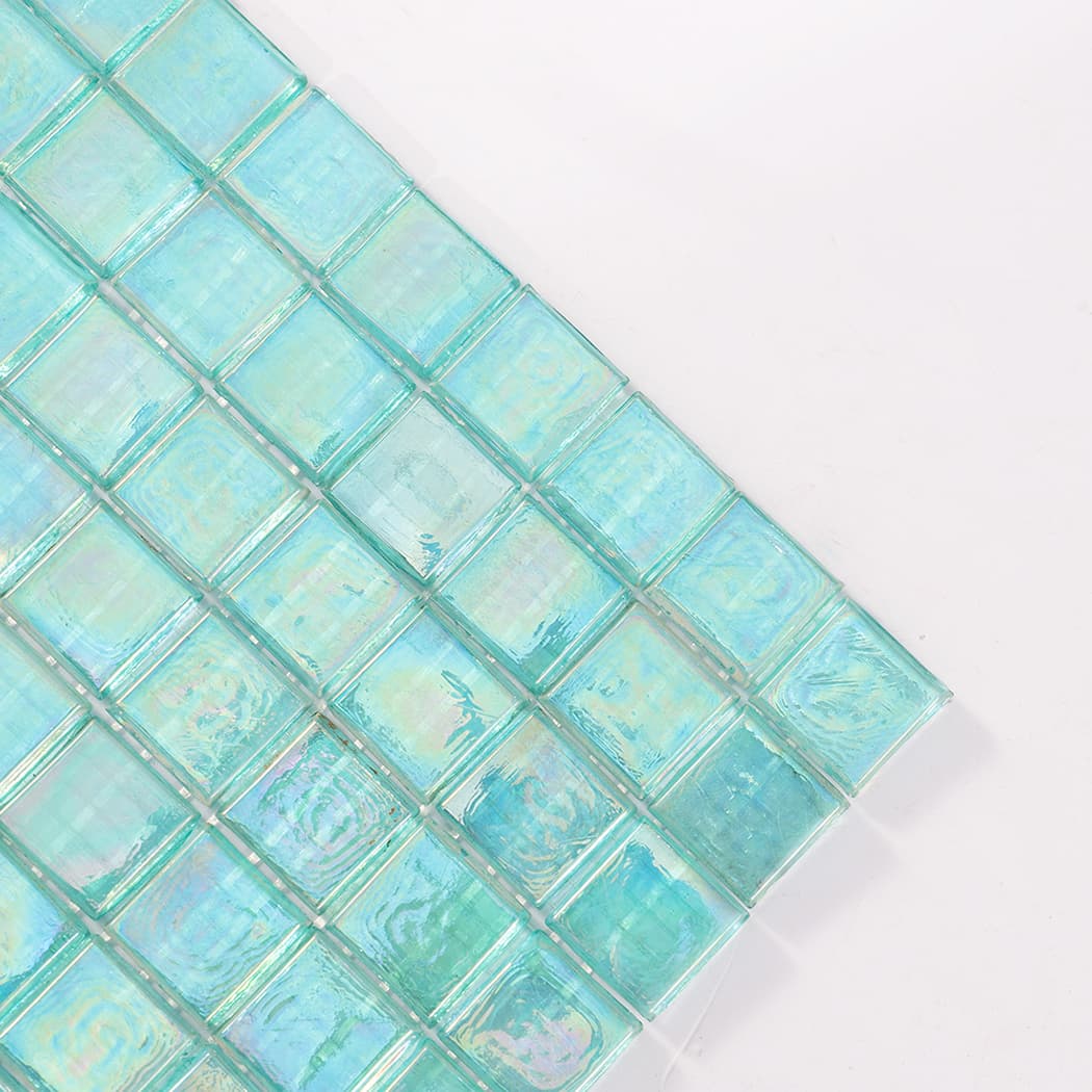 Corner close up of iridescent aqua square glass mosaic tile sheet.