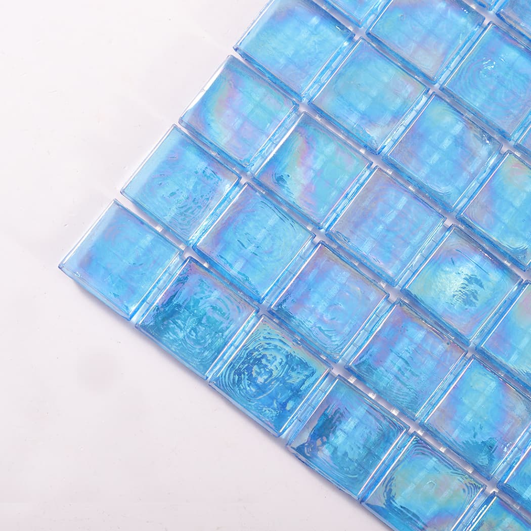 Close up of the corner of iridescent blue square glass mosaic tiles.