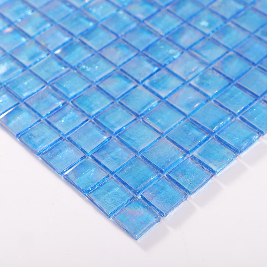 Side angle showing edge thickness of iridescent blue glass mosaic tile sheet.