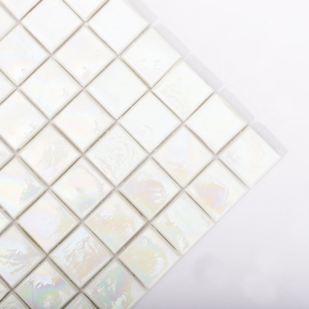 Close up of the corner of iridescent white square mosaic tiles.