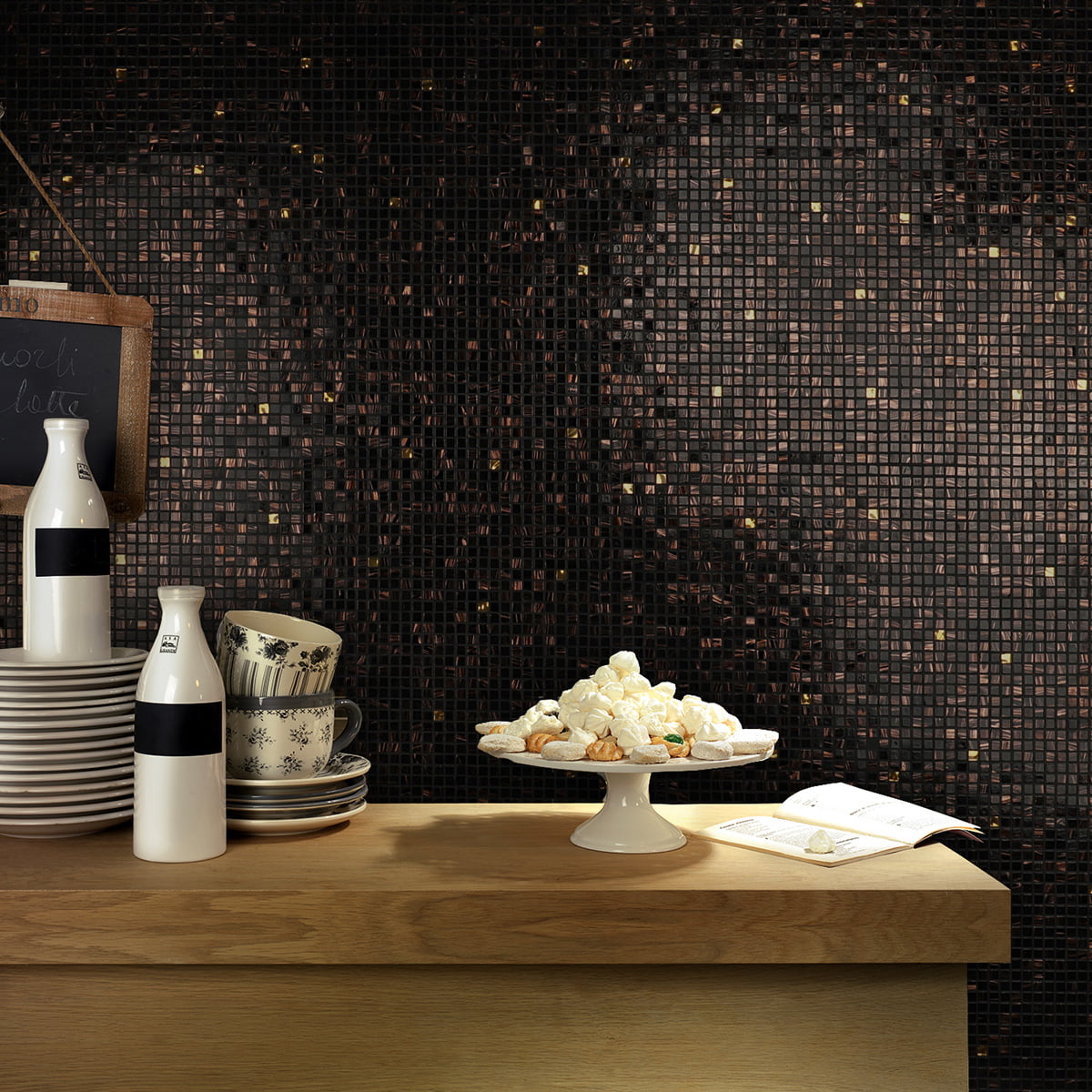 Kitchen backsplash with black mosaic tiles, featuring bronze swirls and gold highlights