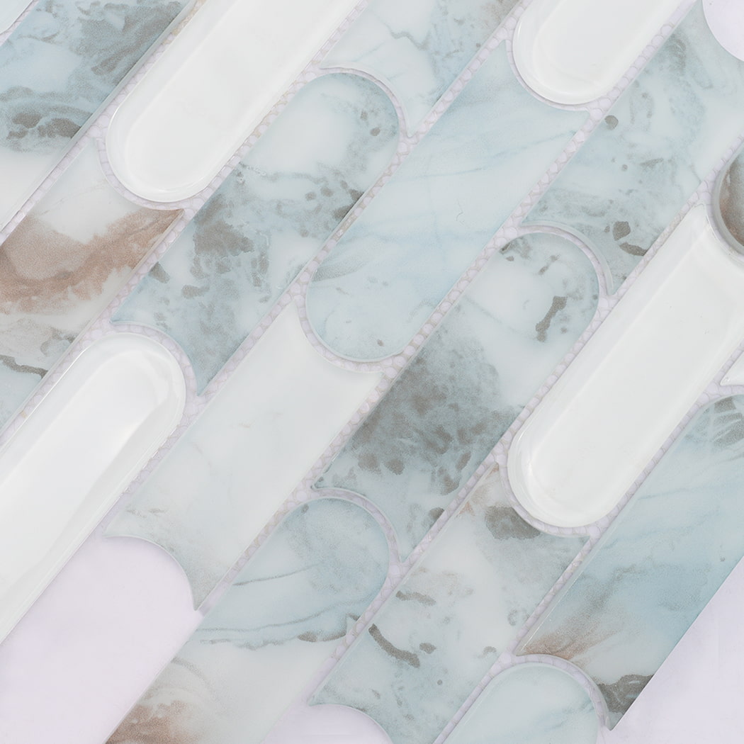 Light blue beige patterned and white pill shaped glass mosaic tile surface detail