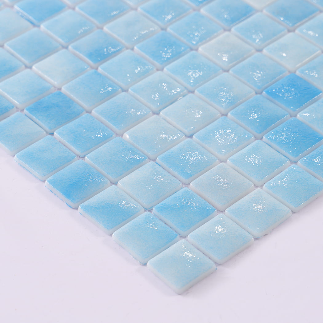 Close up of wet glossy surface on light blue recycled glass mosaic tiles