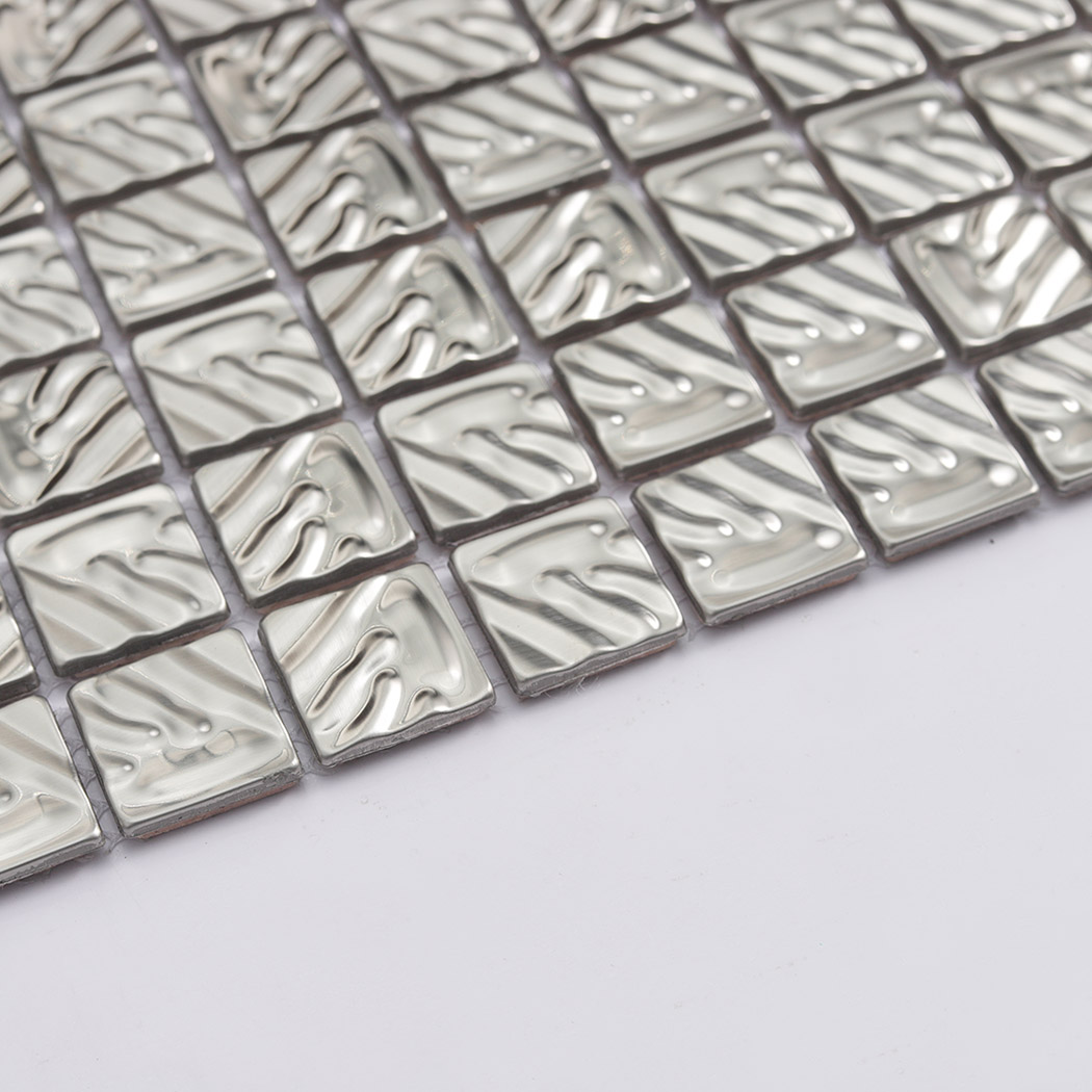 Low angle view of silver stainless steel mosaic showing raised textured surface