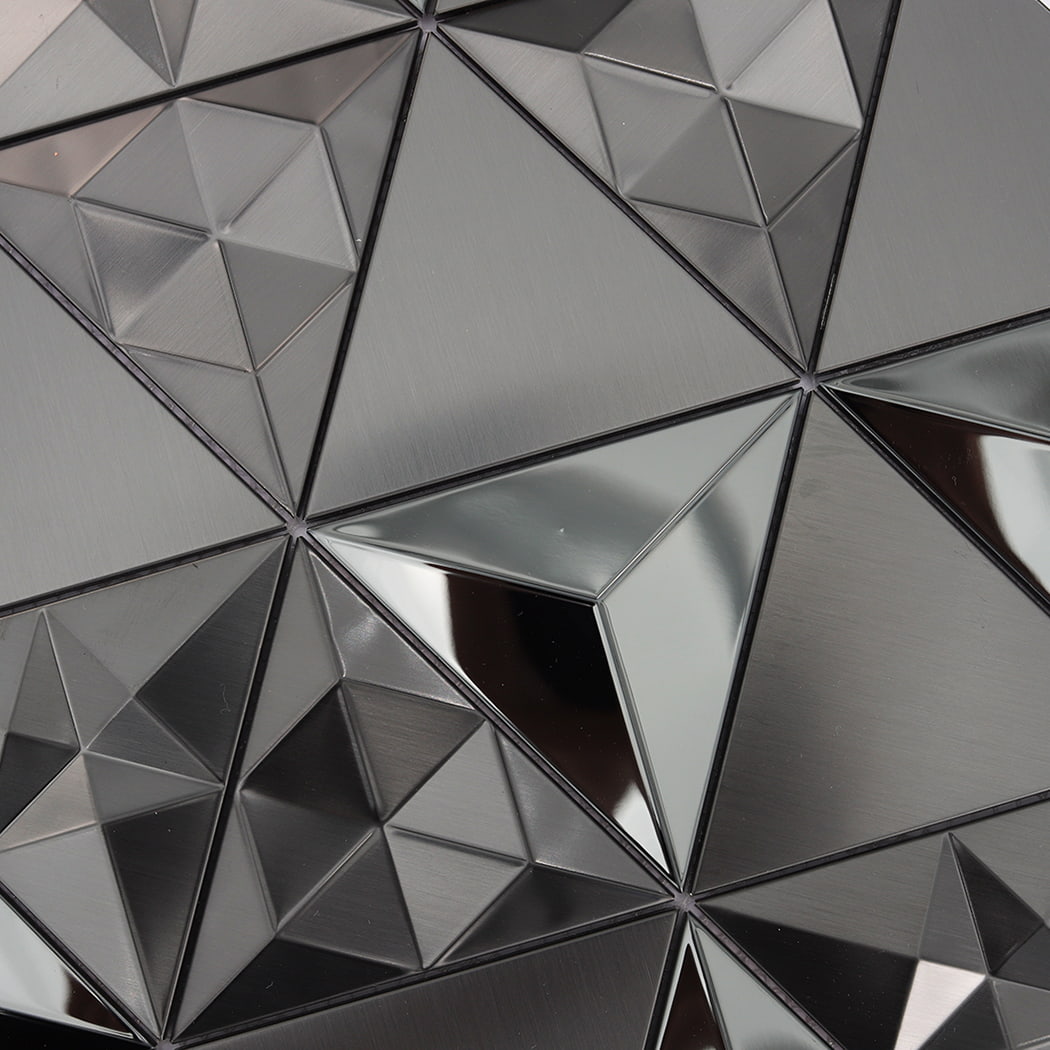 Macro view of black stainless steel 3D triangle tiles showing sharp lines and reflection.