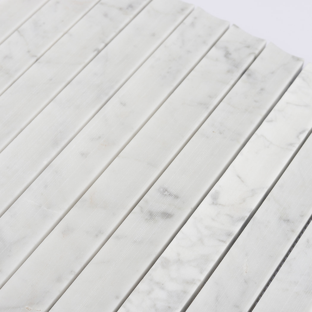 Macro shot of the elegant surface and vein patterns of White Carrara marble fluted tiles.