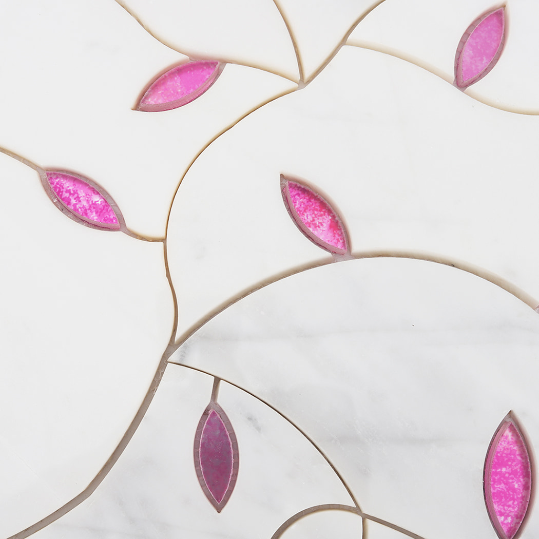 Detailed view of curved marble mosaic pattern with embedded pink glass leaf shapes