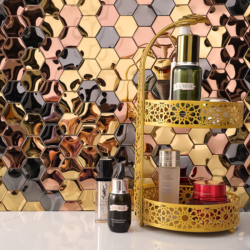 Gold, black, and rose gold hexagonal mosaic backsplash tiles with a beauty product display in front