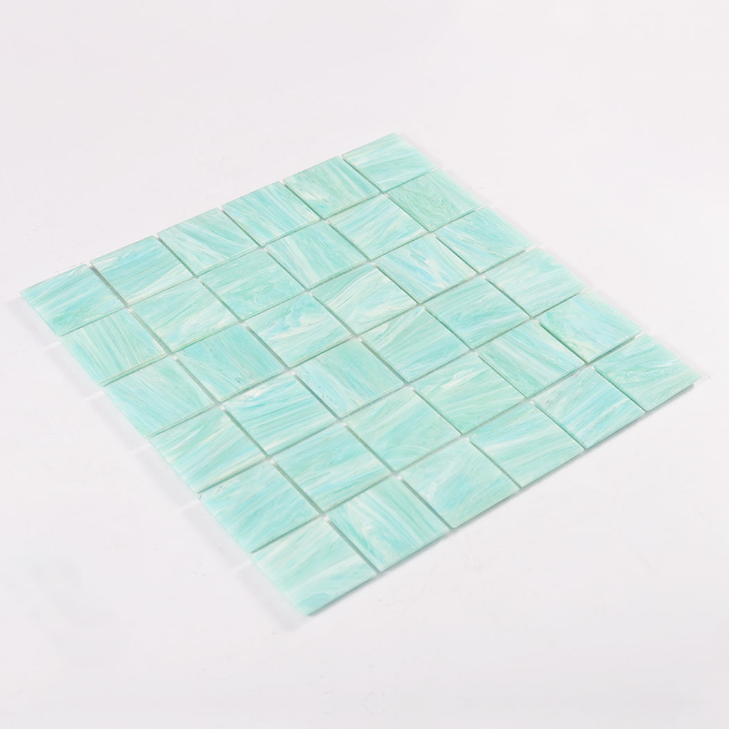 Angled perspective of mint green square glass mosaic sheet on a white background