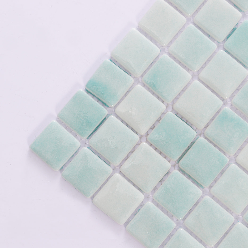 Close-up angled view of mint green mosaic tiles showing texture and glossy surface.