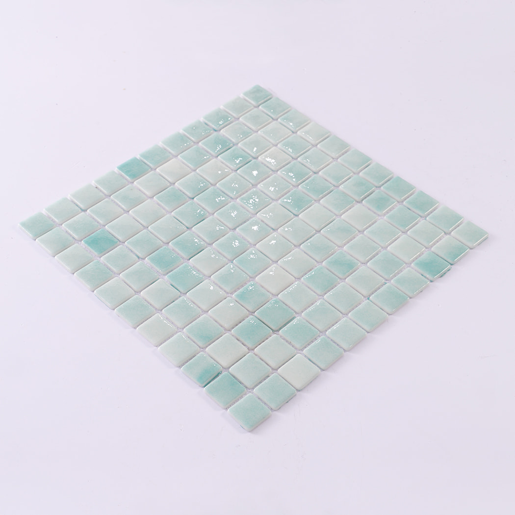 Angled view of a mint green mosaic tile sheet on a white background.