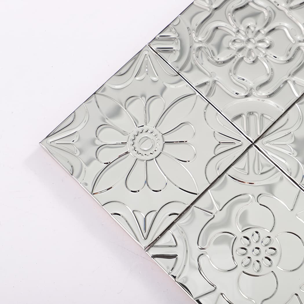 Close up of a daisy relief tile with crisp embossed lines on a mirror silver mosaic sheet.