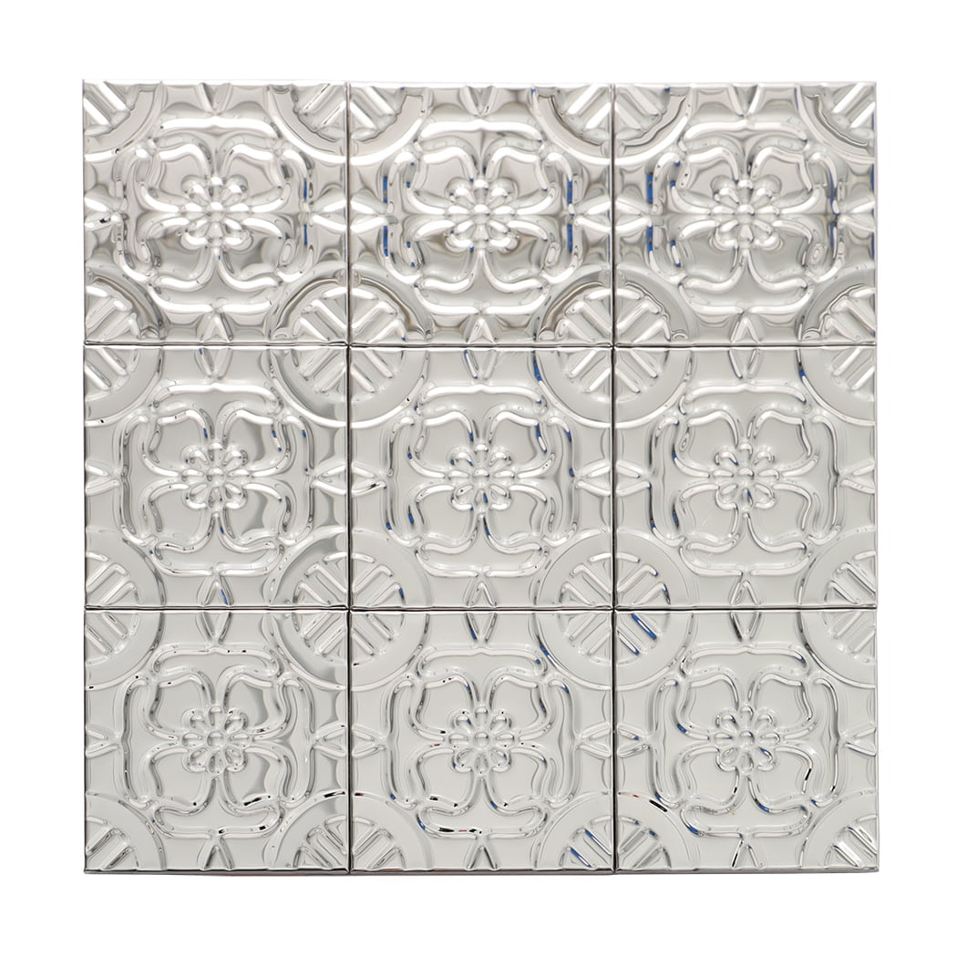 Full view of mirror silver stainless steel mosaic sheet with raised floral relief pattern.