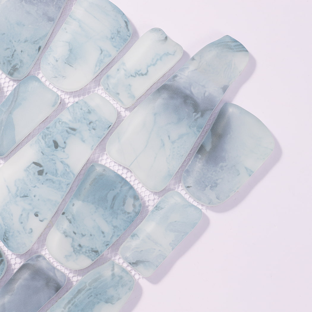 Close-up of misty blue irregular pebble glass tiles with cloudy veining