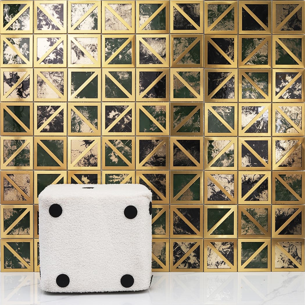 Luxury mosaic wall interior featuring a white plush dice ottoman on a marble floor.