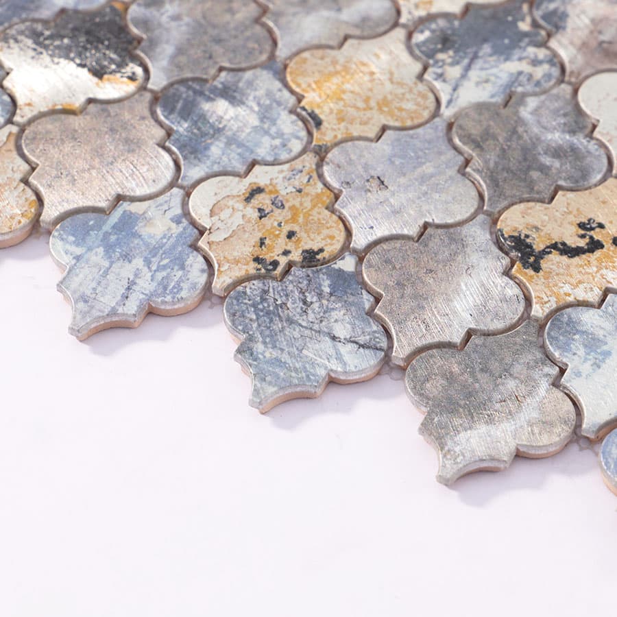 Side angle view of aluminum mosaic tiles revealing cut edges and smooth contour on white background.