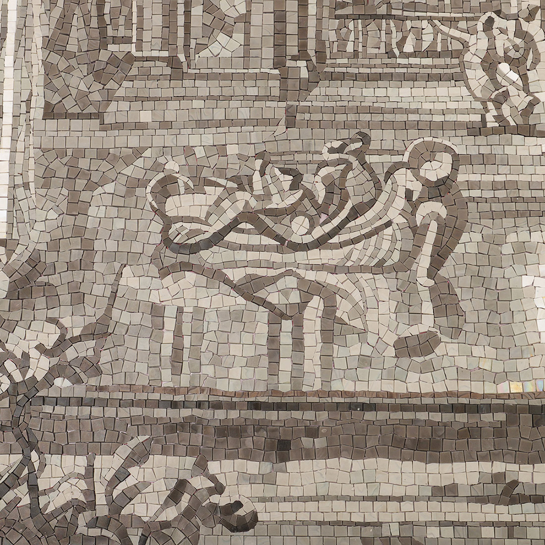 Close-up of a gray mosaic garden bench and decorative scroll pattern