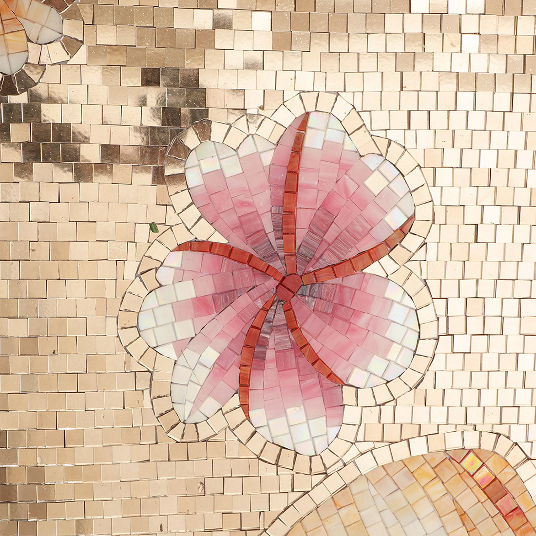 Orange flower detail on a beige handmade glass mosaic mural