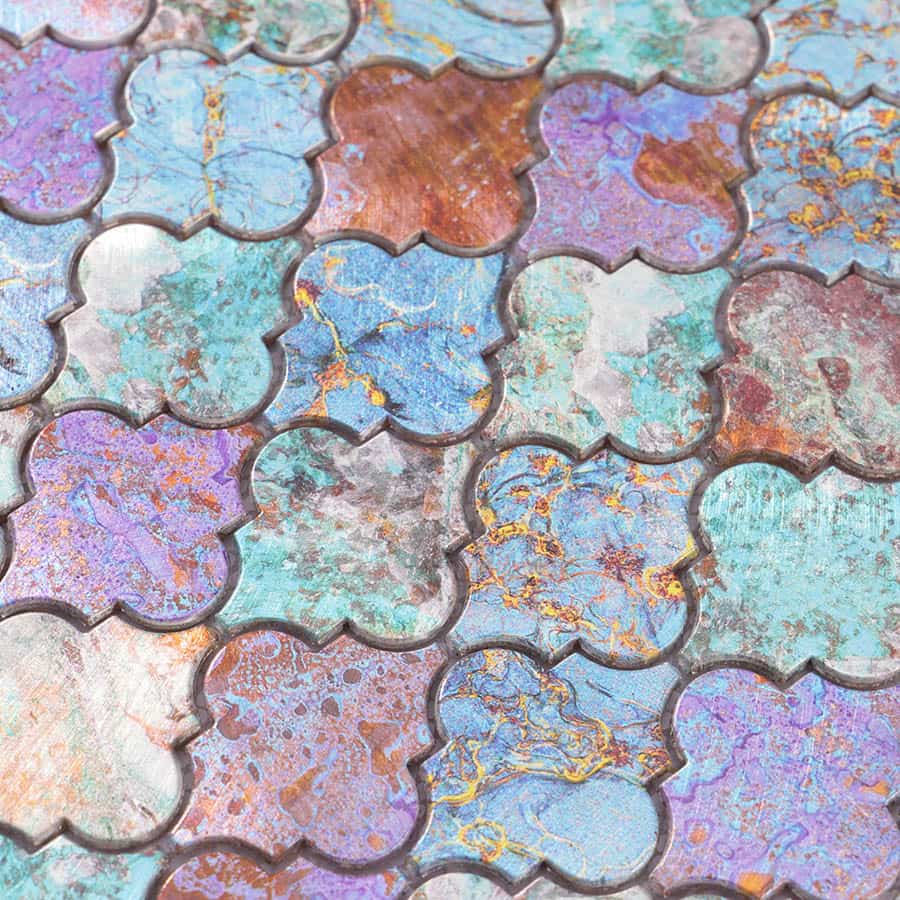Detailed surface view of oxidized Moroccan aluminum mosaic tiles with vivid copper and aqua tones.