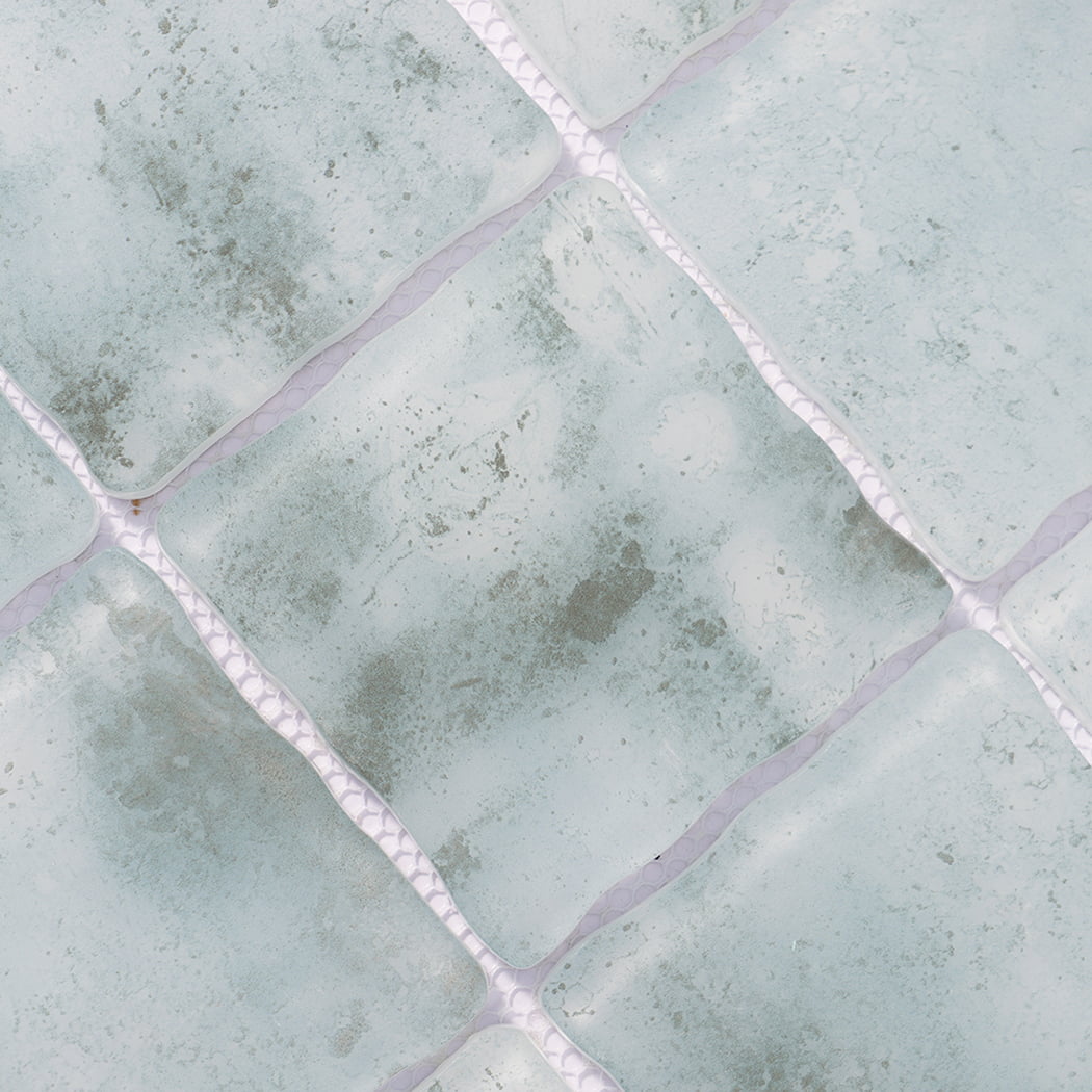 Surface detail of pale aqua wavy square glass mosaic tiles